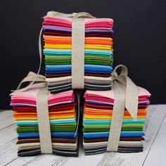 a stack of multicolored cloths sitting on top of a white wooden table