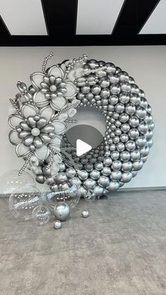 a large metal object sitting in the middle of a room with lots of balls on it