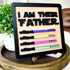 a wooden sign that says i am the father with different colored crayons on it