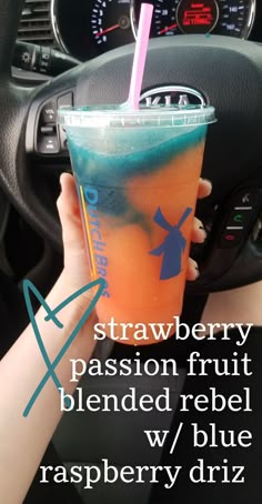 a person holding a drink in their hand with the words strawberry passion fruit blended rebel w / blue raspberry drizzle