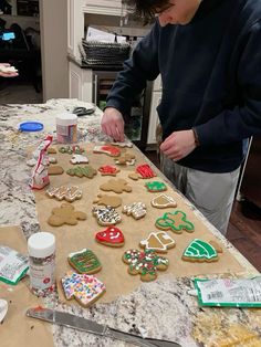 a man is decorating cookies on a table