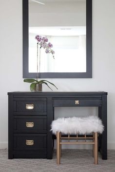 a desk with a mirror and stool in front of it