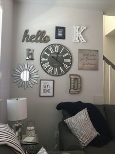 a living room filled with furniture and clocks on the wall