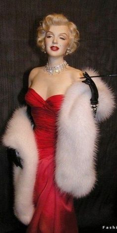 a woman in a red dress and white fur stole with black gloves on her hand