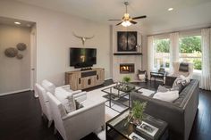 a living room filled with furniture and a flat screen tv mounted on the wall next to a fire place