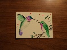 watercolor painting of two hummingbirds on a branch