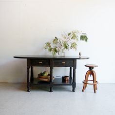 a table with two stools and a potted plant