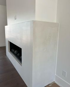 an empty room with a white fireplace in it