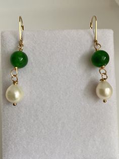 "At an auction last year in Maine, I was able purchase these exquisite pearls. The label on the sleeve indicated that they date back to the 1980s. They boast a stunning creamy white iridescent nacre, radiating elegance. The hand-carved Brazilian emeralds, measuring 12mm, are a recent addition, beautifully complementing the pearls. The lever back is made of 14k gold filled, with a 14k gold stamp, manufactured in the USA. As the birthstone for May, the emerald holds significant meaning. Symbolizing rebirth, it is believed to bestow upon its owner the gifts of foresight, good fortune, and eternal youth. The word \"emerald\" derives from the Greek term \"smaragdus,\" which quite literally translates to \"green,\" reflecting its captivating hue." Green Pearl Jewelry For Gifts, Classic Handmade Pear-shaped Jewelry, Classic Green Pearl Drop Jewelry, Green Round Classic Pearl Earrings, Green Pearl Drop Jewelry As Gift, Green Dangle Pearl Earrings For Anniversary, Green Pearl Drop Jewelry For Gifts, Formal Green Jewelry With High Luster, Formal Green High Luster Jewelry