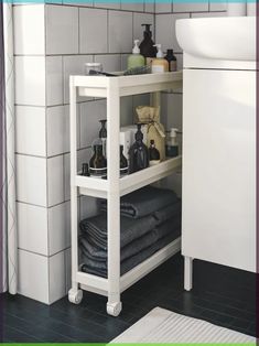 a white shelf with towels and soaps on it next to a sink in a bathroom