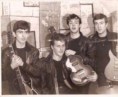 an old black and white photo of four young men holding guitars