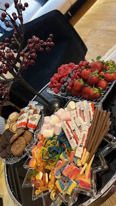 an assortment of snacks are arranged on a glass platter in front of a tree