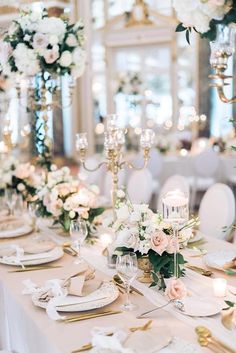 the table is set with white flowers and candles for an elegant wedding reception in ukraine