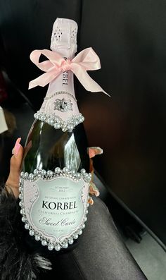 a woman holding a bottle of korbel champagne