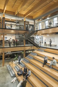 people are sitting on the stairs in an open building