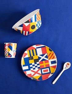 an assortment of colorful plates and cups on a blue surface