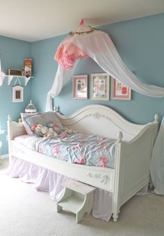 a white bed sitting in a bedroom next to a window