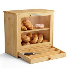 a wooden display case filled with donuts and croissants on top of it