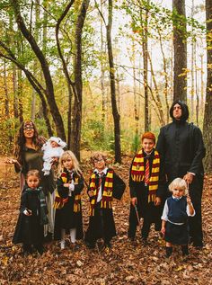 a group of people dressed up in harry potter costumes posing for a photo with their children