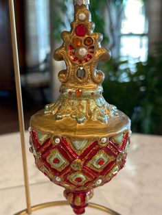 a gold and red ornament sitting on top of a table