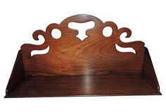 a wooden shelf with carved designs on it