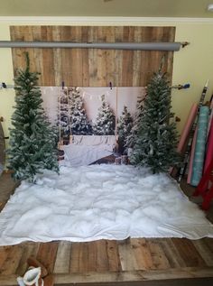 a bed made out of pallet wood with snow on the ground and trees in front of it