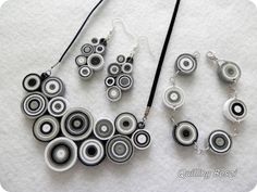 two necklaces and earring set made out of metal beads on a white surface