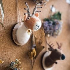 two deer head ornaments are hanging on the wall next to other animal figurines