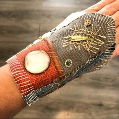 a person's arm with an insect on it and buttons attached to the wrist