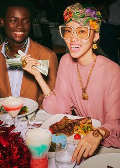 two people sitting at a table with plates of food