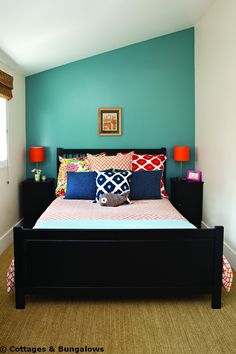 a bed sitting in a bedroom next to two lamps on either side of the bed