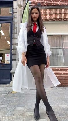 a woman dressed in black and red posing for the camera