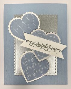 a card with two hearts and congratulations ribbon