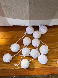 several white pom - poms on a wooden floor