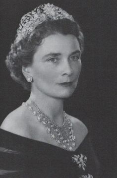 an old black and white photo of a woman wearing a tiara with pearls on it