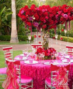 the table is set with pink and red flowers