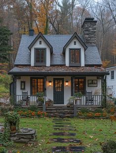 a white house in the woods with steps leading up to it's front door