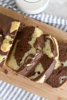 slices of chocolate marbled cake on a wooden cutting board next to a glass of milk