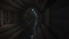 a dark tunnel with water running through it and lights shining on the floor at the end