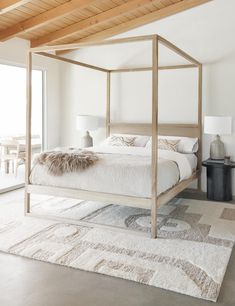 a bedroom with a bed, rugs and lamps on the floor in front of a sliding glass door