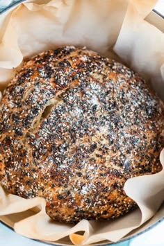 a loaf of bread sitting inside of a metal pan on top of a blue and white table cloth