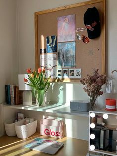 a desk with some flowers and pictures on the wall