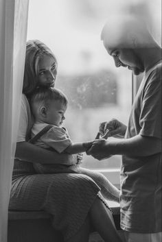 black and white photograph of a woman holding a small child in front of a window