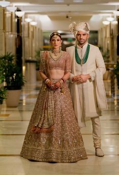 a man and woman standing next to each other in formal wear, posing for the camera