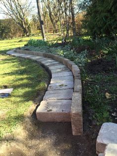 a stone path in the middle of a grassy area