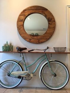 a bicycle is parked in front of a wall with a round mirror on the wall