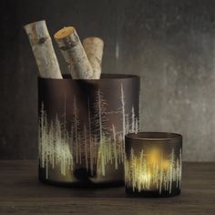 a candle holder with two candles in it sitting on a table next to a vase