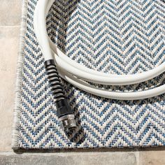 a close up of a white and black cable on top of a blue and white rug