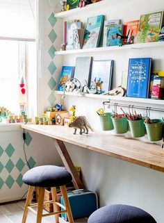 a child's room with toys and books on the shelves, along with two stools