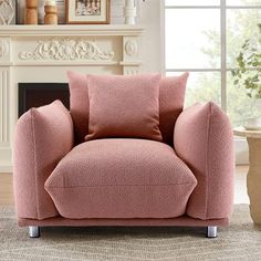 a pink chair sitting in front of a fireplace with pillows on it's back